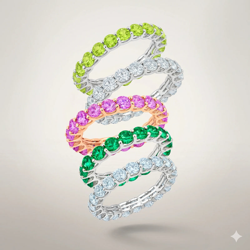 Three intertwined rings with colorful gemstones on a light gray background