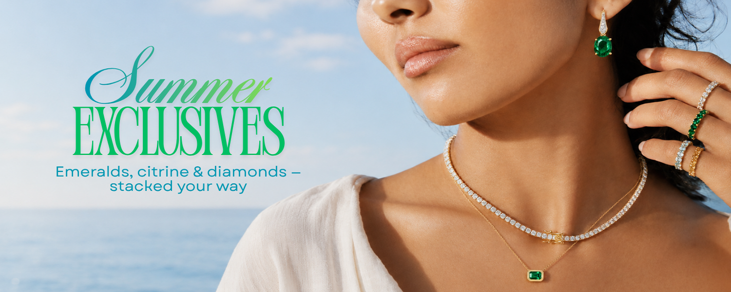 Woman wearing emerald, citrine, and diamond jewelry with a blue sky background
